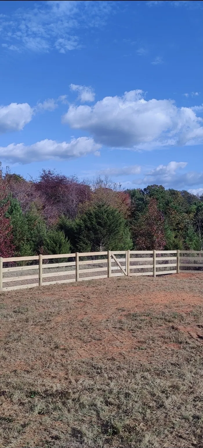 Wood rail fence and gate under an autumn sky