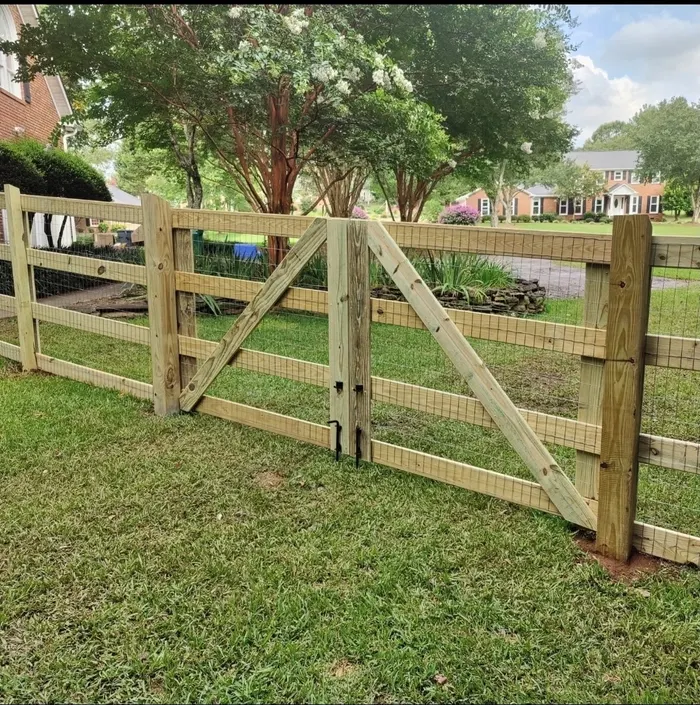 Wood rail gate framed by a flowering crepe myrtle
