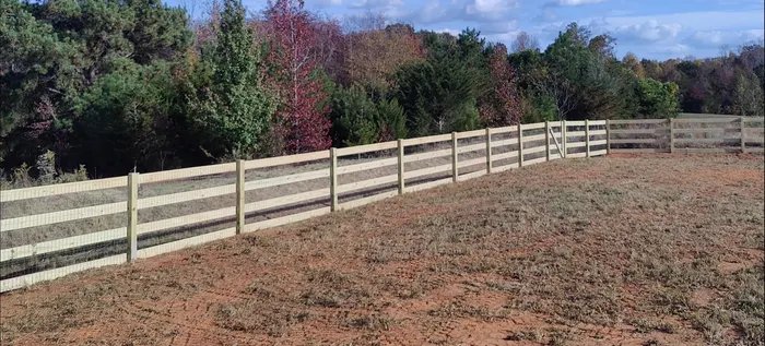 Wood rail fence along a red-clay field edge