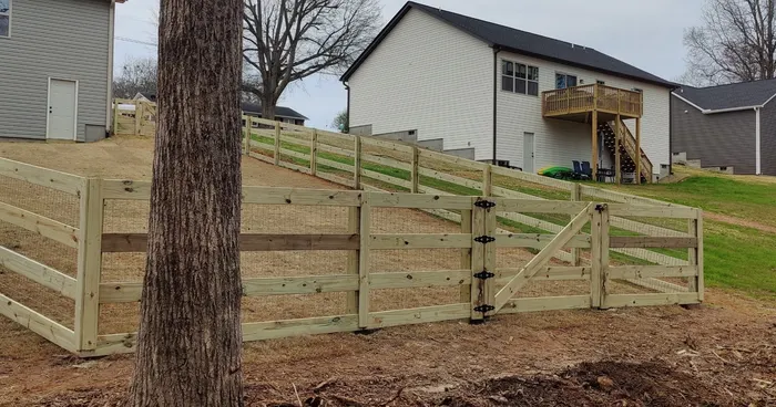 Wood rail fence enclosing a hillside backyard