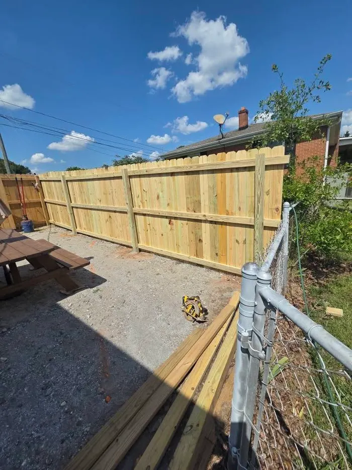 Finished cedar picket fence enclosing a gravel patio